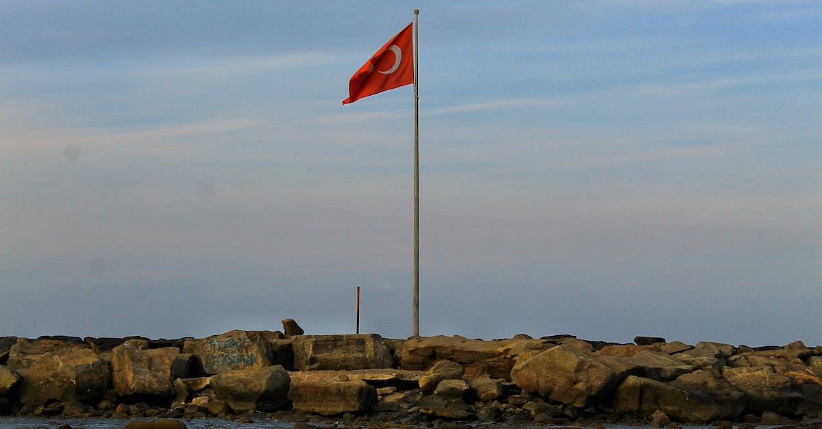 Influencing Colonial Nation wars - Turkish Flag waving over stones near sea