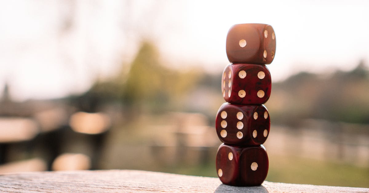 In-game settings cannot be modified - Set of red dice stacked together on wooden table placed on sunny terrace in daylight In-game settings cannot be modified - Set of red dice stacked together on wooden table placed on sunny terrace in daylight