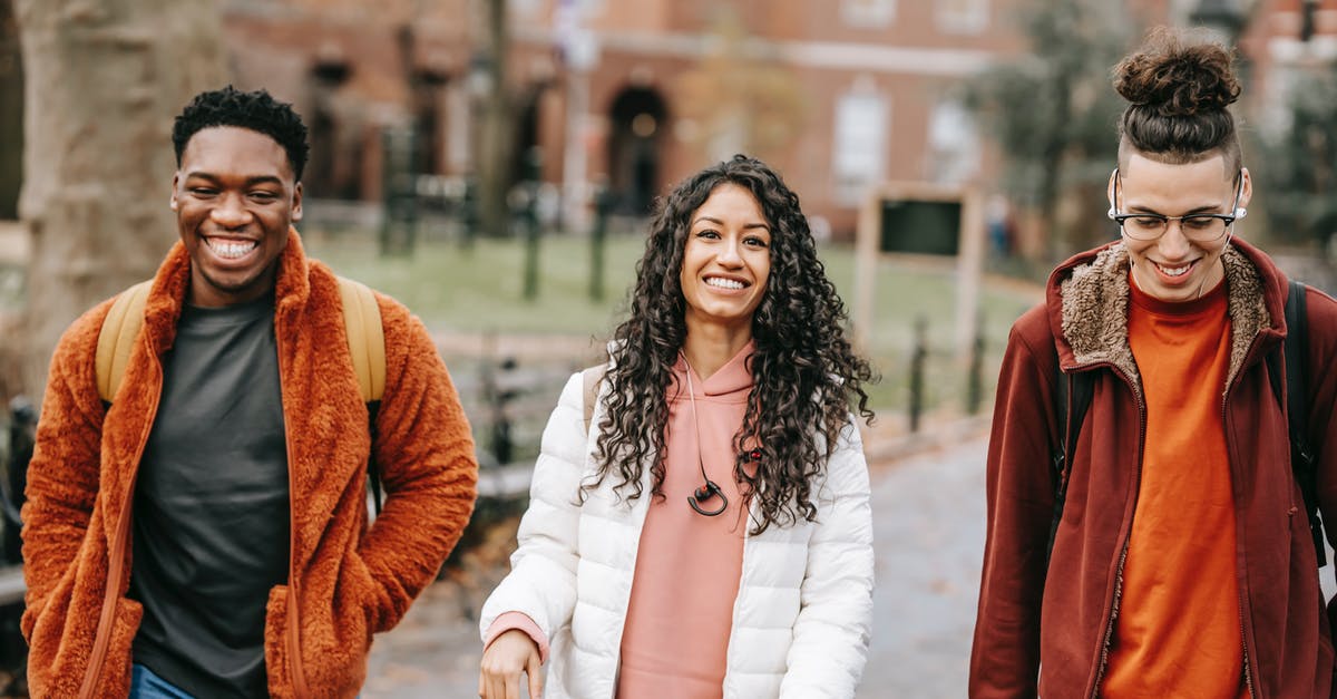 Ingress factions: only appears to be one group in my city - Happy multiracial friends in trendy outfits smiling while strolling together in city park
