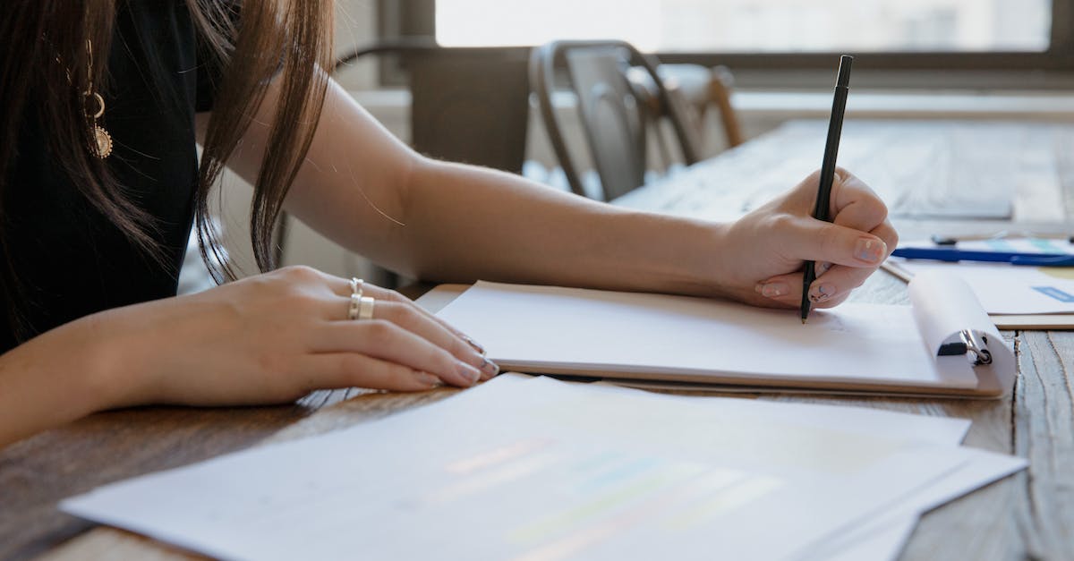 Inserting items into Writing Desk - Woman in White Tank Top Writing on White Paper
