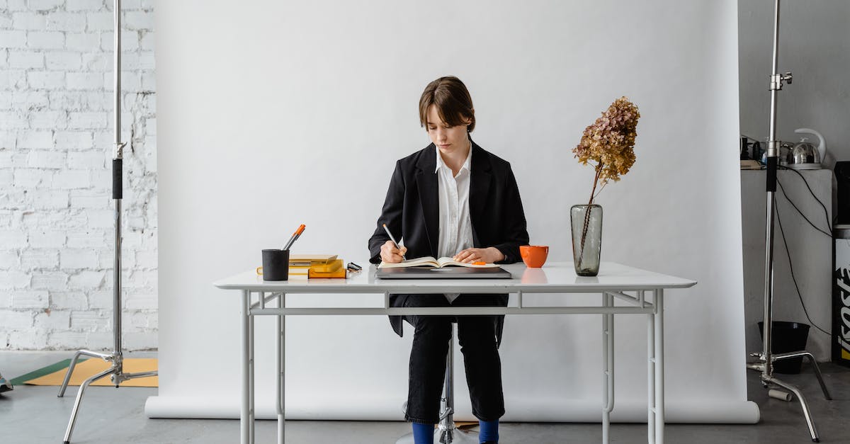 Inserting items into Writing Desk - Man and Woman Sitting on Chair in Front of Table