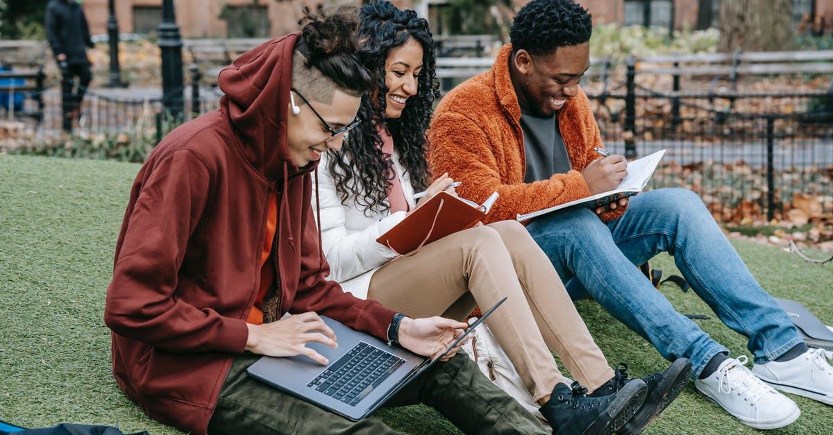 Inviting my friend to my minecraft pc singleplayer world [duplicate] - Happy multiracial group of students in casual clothes sitting together on grass and studying with laptop and books