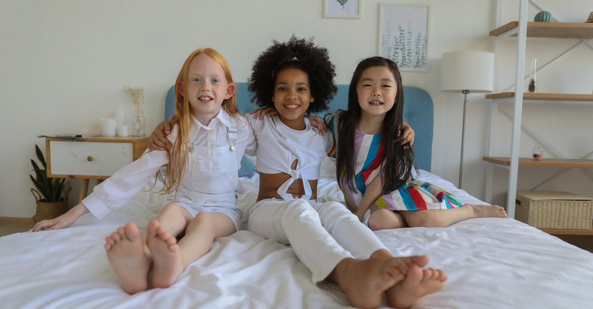 Is 1st generation GBA bright enough for indoor use? - Happy cute little diverse girls with bare feet resting on cozy soft bed in modern comfortable room