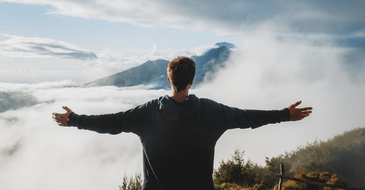 Is a Pokémon's weight and height relevant? - Back view of anonymous male traveler in casual clothes standing on edge of cliff and admiring breathtaking scenery of clouds and mountain top