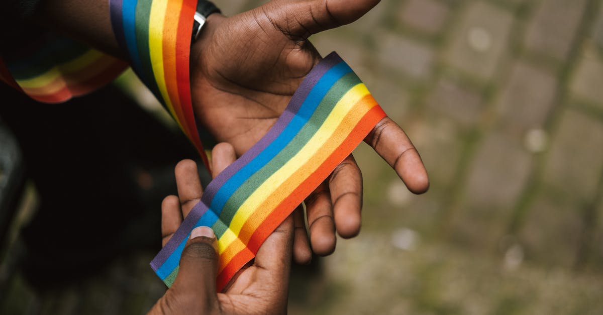 Is a pokemon's gender determined before it hatches from its egg? - From above crop African American gay demonstrating colorful rainbow ribbon on hand against paved sidewalk