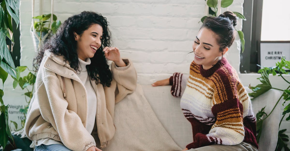 Is chat available to Xbox Live Free? - Side view of young woman in casual clothes sitting on sofa and talking while spending weekend together