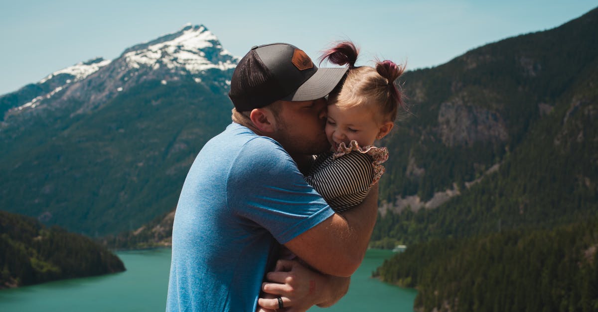 Is Emily Kaldwin really Corvo's daughter? - Man Wearing Blue Crew-neck T-shirt Holding Girl Near Mountains