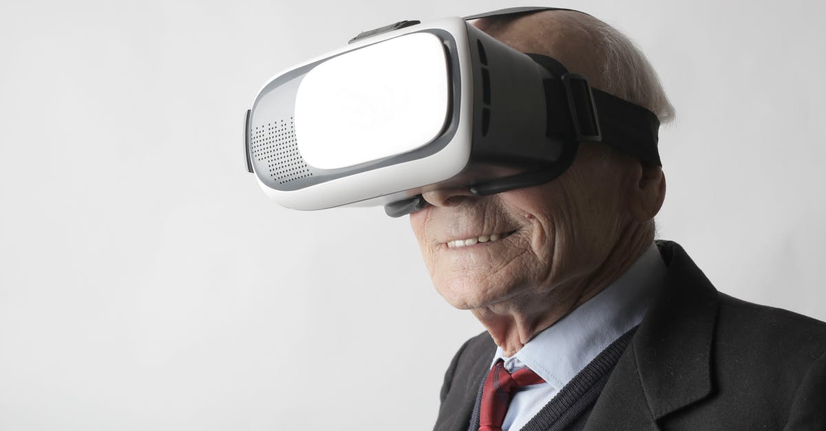 Is experience the same regardless of level? - Smiling elderly gentleman wearing classy suit experiencing virtual reality while using modern headset on white background