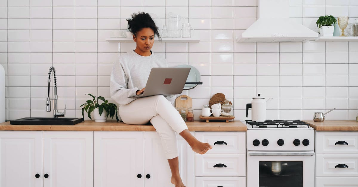 Is GTA Online cross-platform? - Woman in White Long Sleeve Shirt and White Pants Sitting on White Kitchen Counter