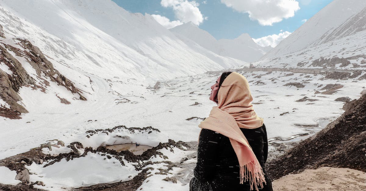 Is Ice Climber limited to level 60? - Woman in Black Dress Sitting on Rock at the Valley Covered in Snow