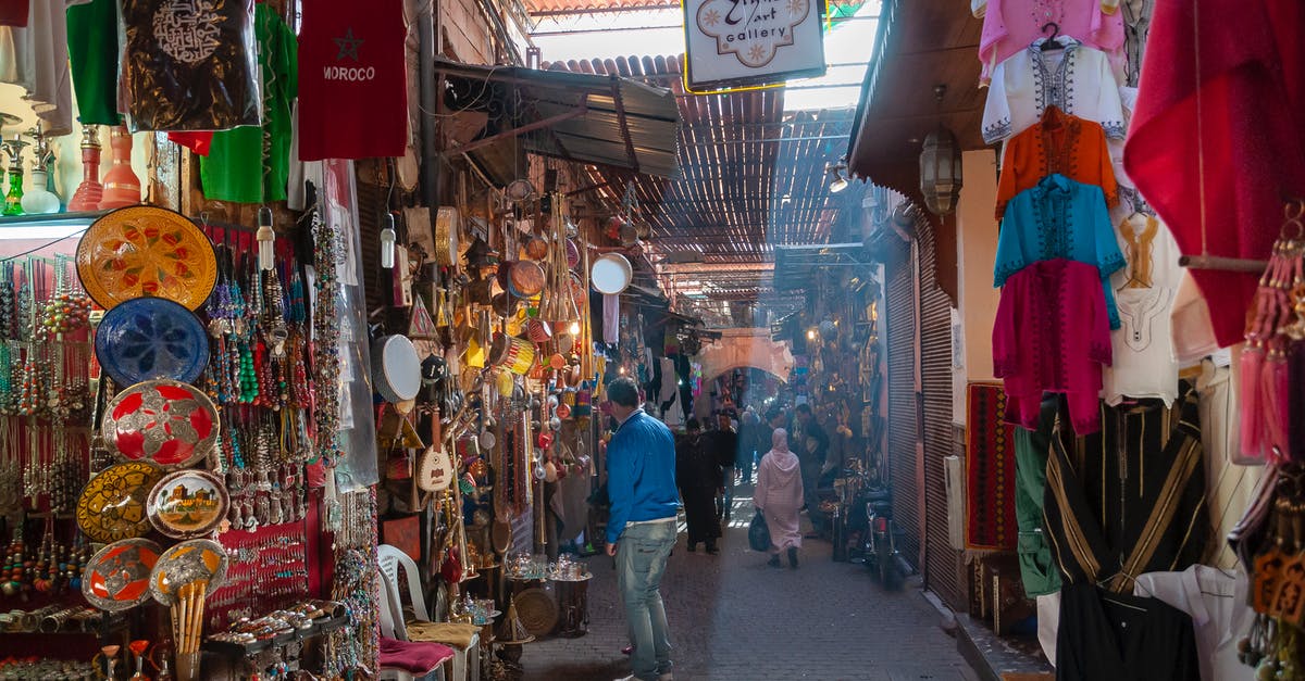 Is it better to sell or scrap your items? - Unrecognizable people walking in local bazaar near stalls with various goods and souvenirs and traditional clothes on sunny day in Marrakesh