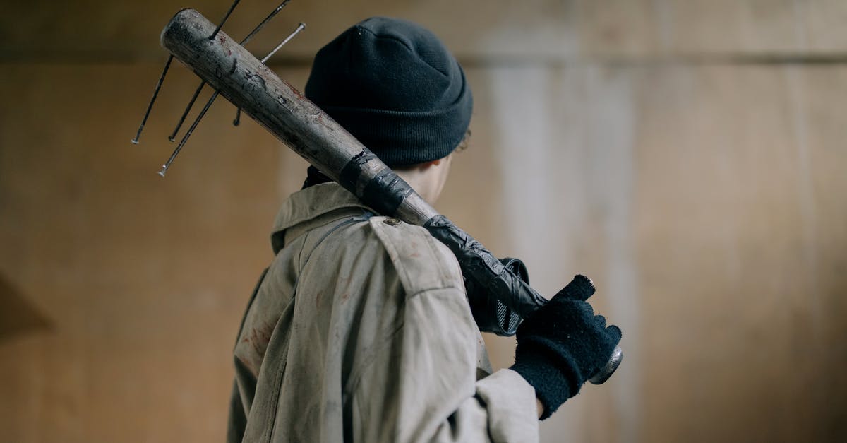 Is it better to use high damage, slower weapons? Or lower damage, faster weapons? - Person in Black Knit Cap and Beige Coat Holding Brown Wooden Stick