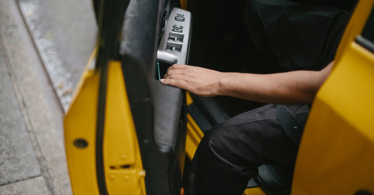 Is it dangerous to leave my car idling while I sleep in a garage? - Unrecognizable man getting out of yellow car Is it dangerous to leave my car idling while I sleep in a garage? - Unrecognizable man getting out of yellow car