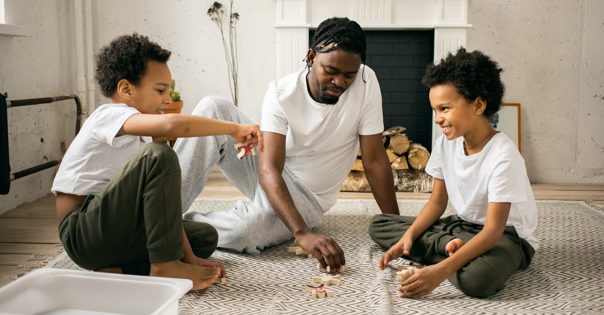 Is it easier to have aliens of similar races on your planet? - Full body of cheerful African American twin brothers in similar casual clothes smiling while sitting on floor and playing with toys together with happy young father Is it easier to have aliens of similar races on your planet? - Full body of cheerful African American twin brothers in similar casual clothes smiling while sitting on floor and playing with toys together with happy young father