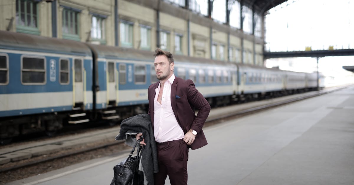 Is it possible for a 3ds to act as the source and destination of system transfers without having to wait 7 days in between? - Serious stylish businessman in elegant white shirt and purple jacket holding leather bag and coat in hand standing on platform on railway station and waiting for train
