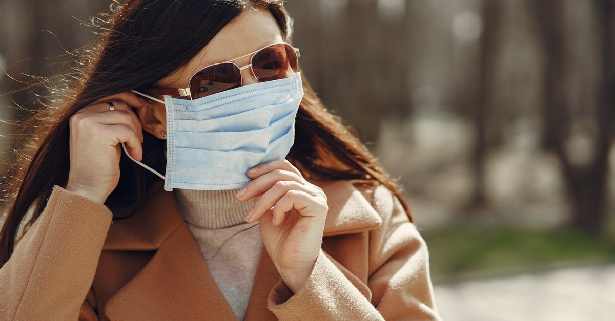 Is it possible to adjust your walk speed? - Casual female in warm coat and sunglasses putting on medical mask during stroll in autumn park at daytime against blurred background Is it possible to adjust your walk speed? - Casual female in warm coat and sunglasses putting on medical mask during stroll in autumn park at daytime against blurred background
