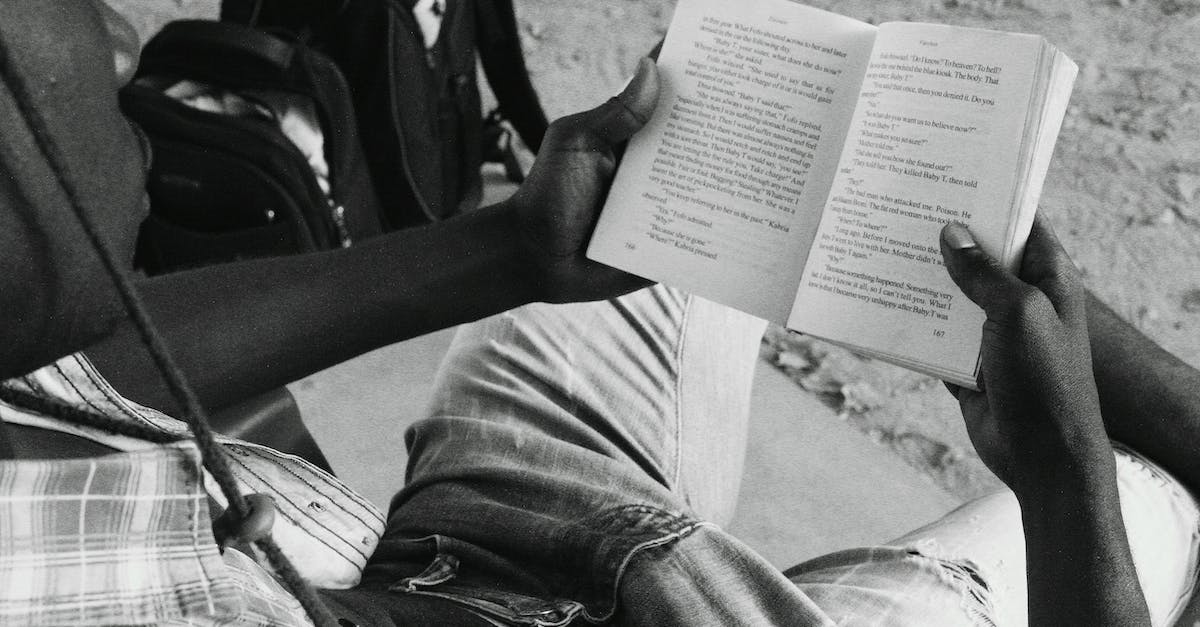 Is it possible to change the outfit characters wear in the story mode? - From above black and white of anonymous African American male sitting near stone road while reading book in street outside
