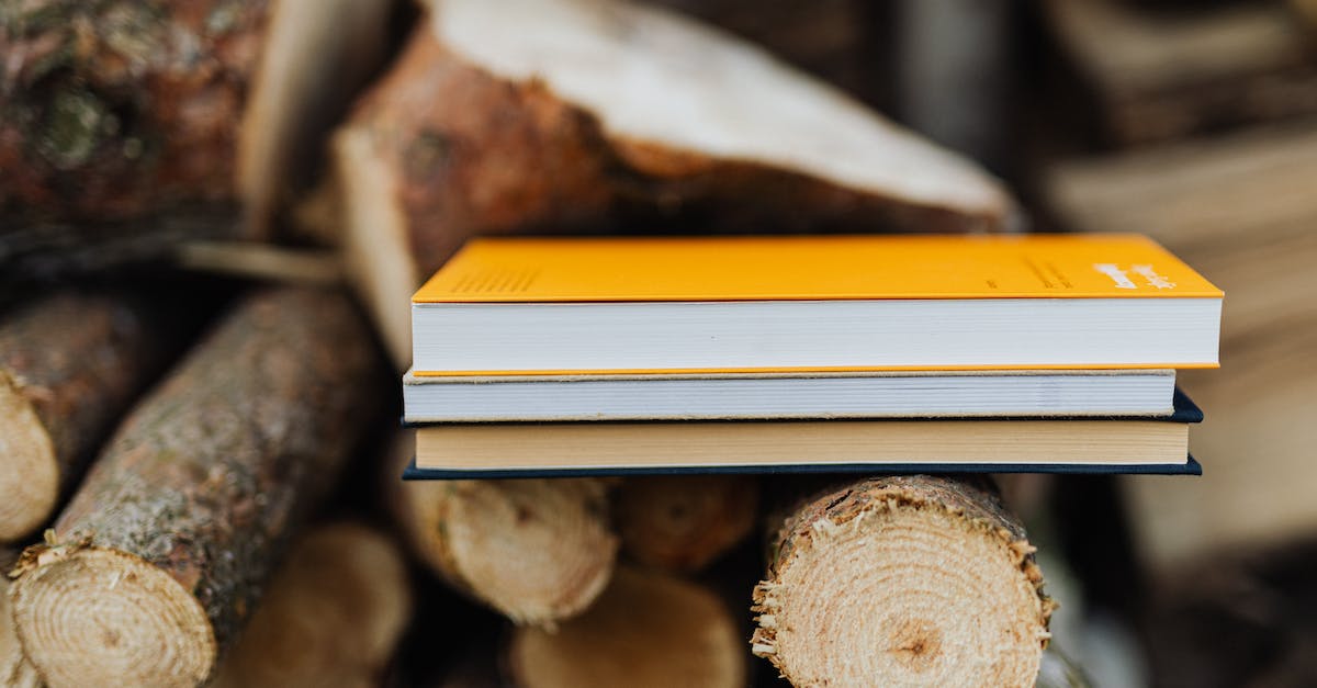 Is it possible to chop down trees? - Books placed on edge of freshly prepared woodpile in backyard of countryside house