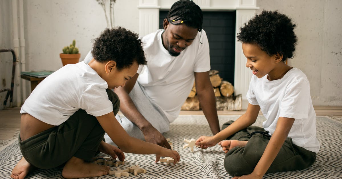Is it possible to create a custom ore and add it to world generation with a Datapack? - Happy young African American father in casual outfit smiling while sitting on floor and playing with wooden toys with positive twin sons during weekend at home