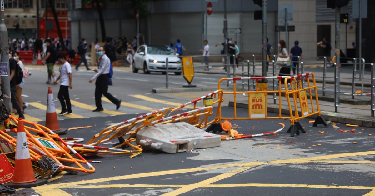 Is it possible to destroy a road that I previously placed? - Crowd of people walking on sidewalk and pedestrian crossing on street with damaged fences after mass meetings