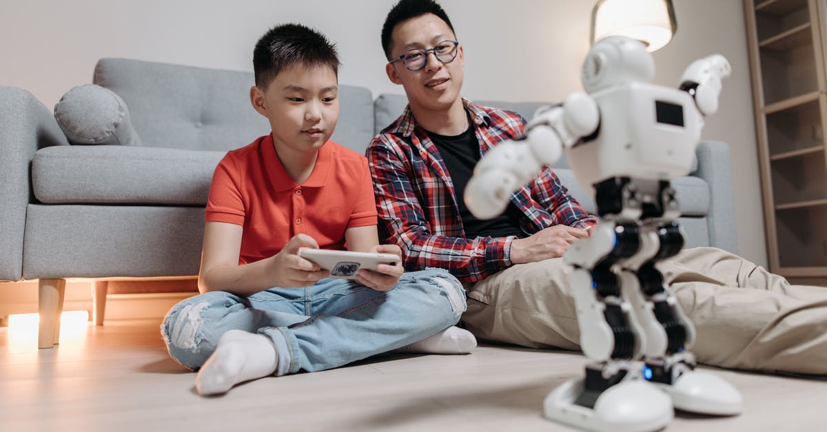 Is it possible to earn Steam Achievements when playing Remotely? - A Man Sitting Next to a Boy Holding a Remote Controller Playing With a Robot Toy