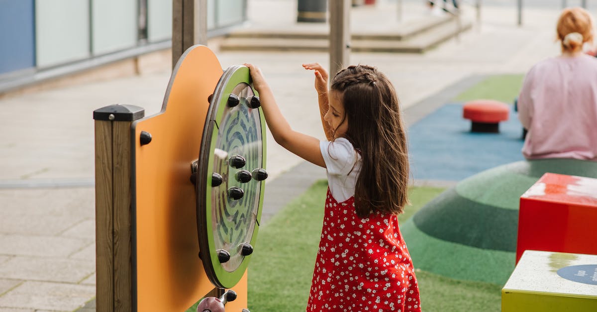 Is it possible to have a stable small community? - Side view of little girl playing with toy on playground in casual outfit in daytime on street