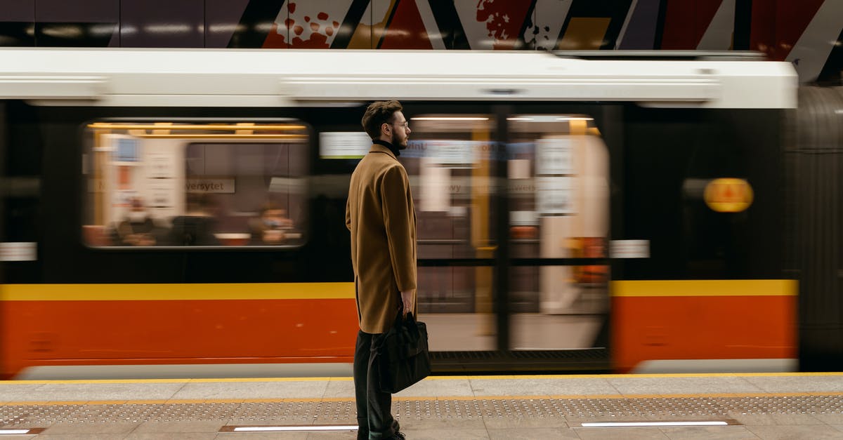 Is it possible to make a moving platform below a player's feet? - A Man in Brown Coat Standing on a Subway Platform with a  Moving Train