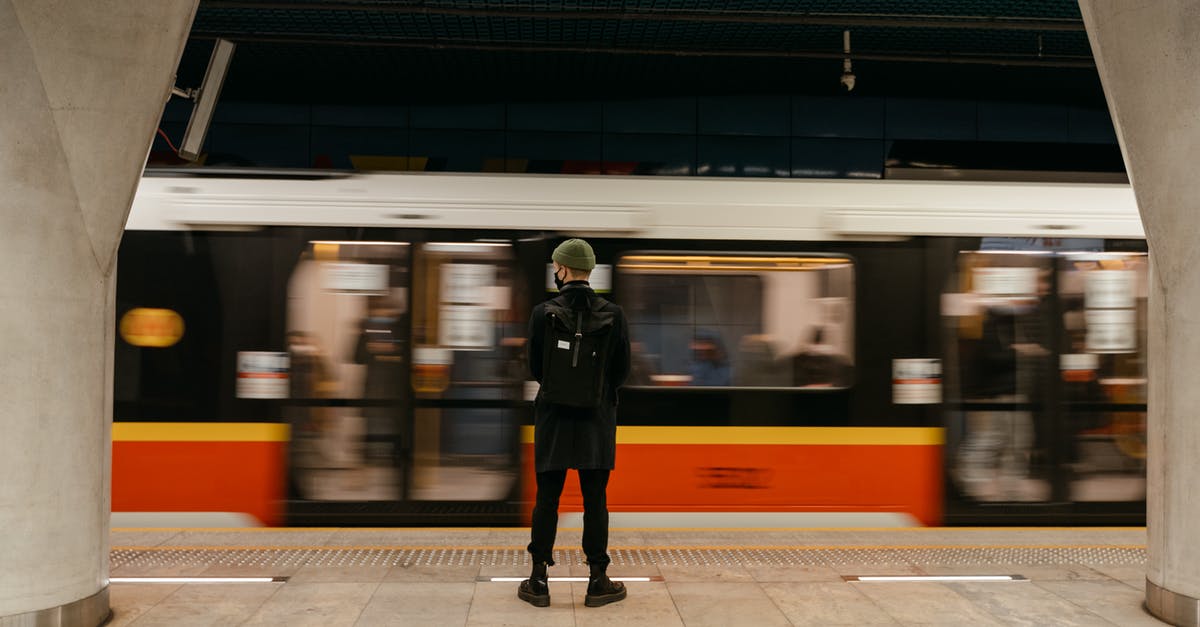 Is it possible to make a moving platform below a player's feet? - A Person Standing on the Subway Platform with a Train Passing