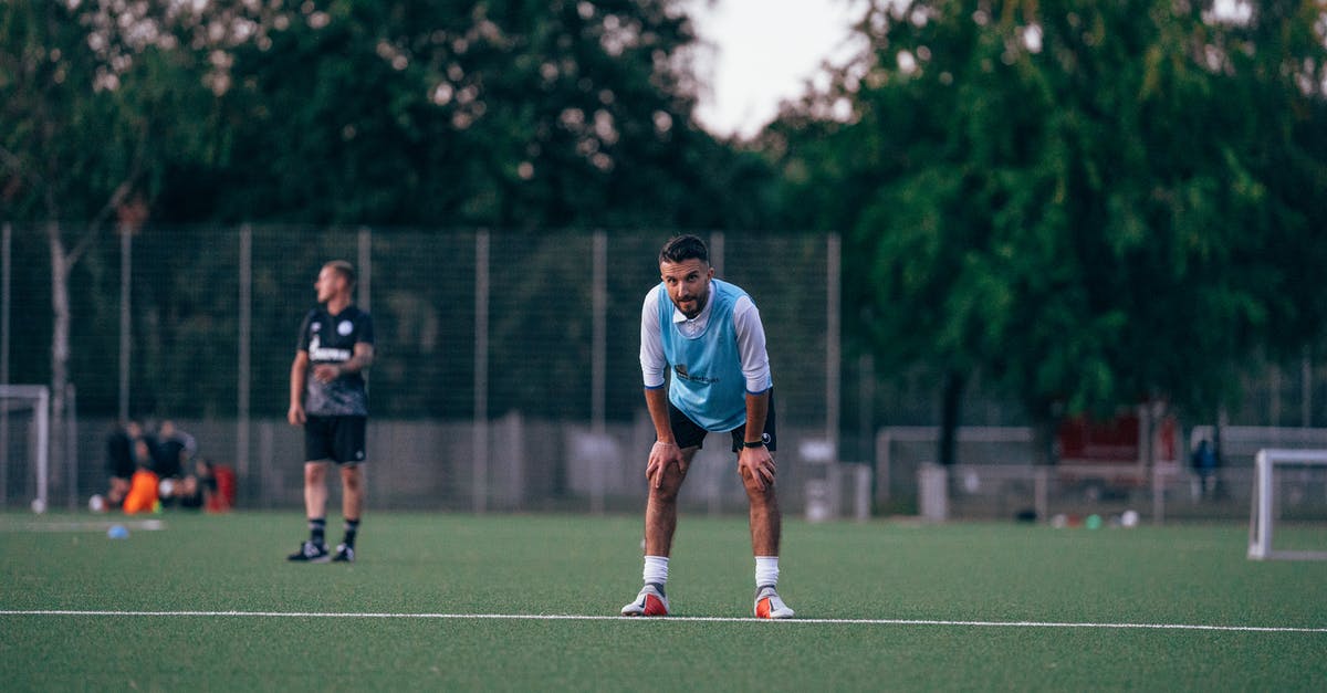 Is it possible to pause a game across restarts? - Football player standing in field during training