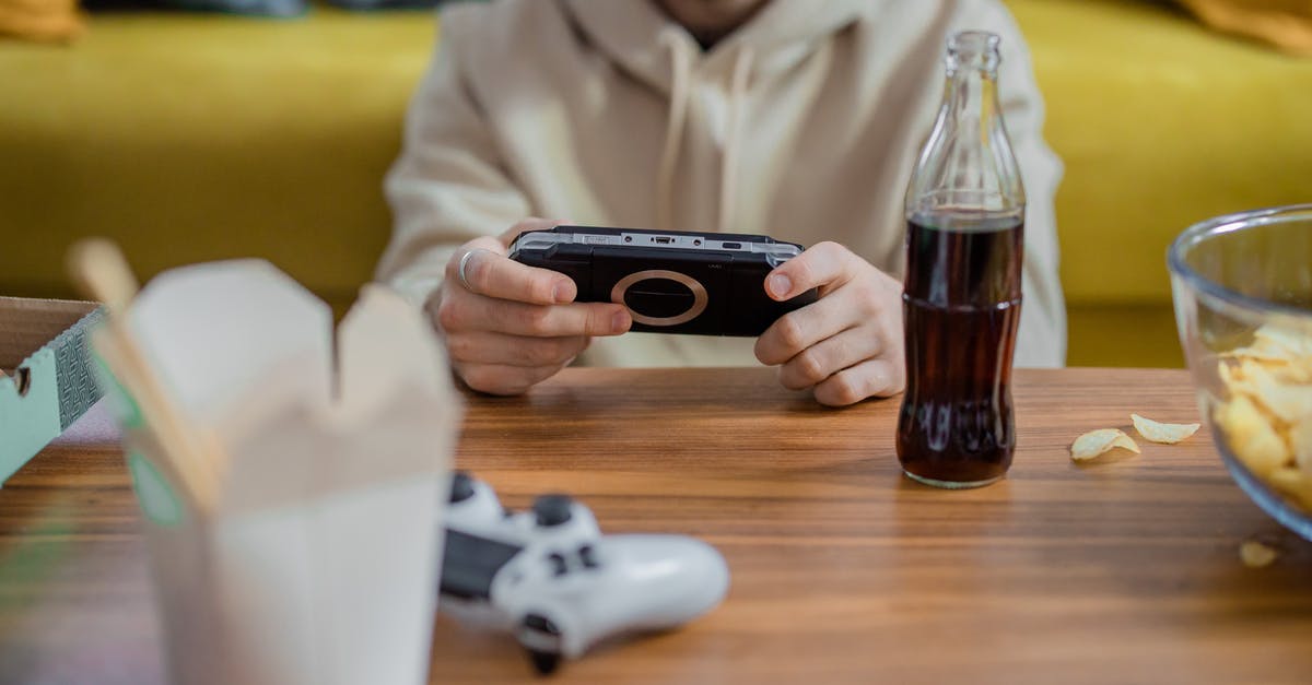 Is it possible to play a PSP Game brought from the Playstation Store on a PSP Emulator? - A Person Holding a Game Console Is it possible to play a PSP Game brought from the Playstation Store on a PSP Emulator? - A Person Holding a Game Console