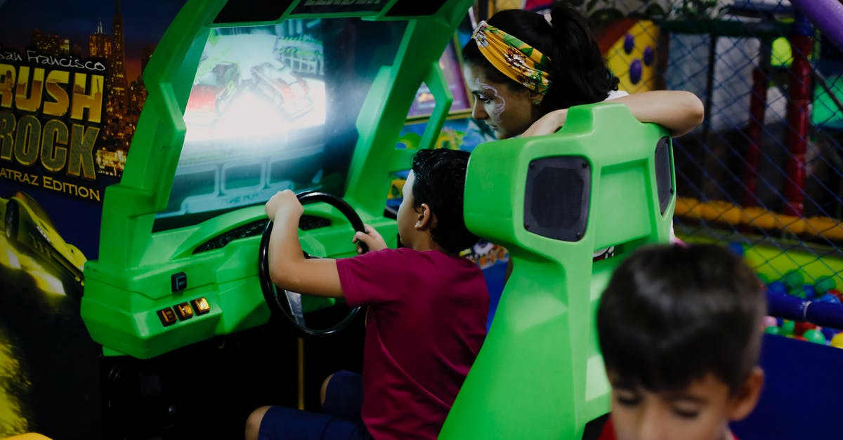 Is it possible to play car racing games with a joystick? - Anonymous boy playing car racing simulator near mother and sibling Is it possible to play car racing games with a joystick? - Anonymous boy playing car racing simulator near mother and sibling