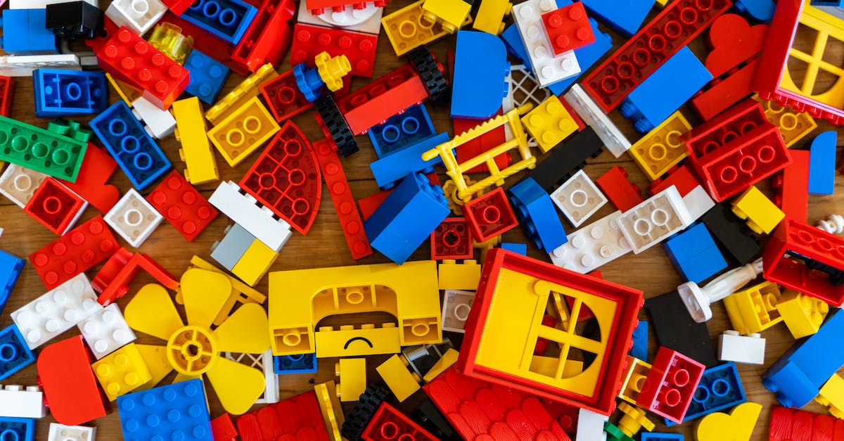 Is it possible to play on friend's world in a different part of the country? - Top view of various pieces of colorful plastic construction toys scattered on wooden floor as abstract background