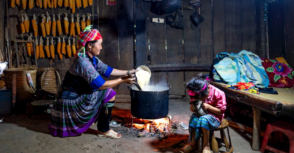 Is it possible to play the Steam version of Quake on Ubuntu? - Content ethnic mom in traditional wear pouring rice into cauldron above fire against anonymous girl playing with cat at home