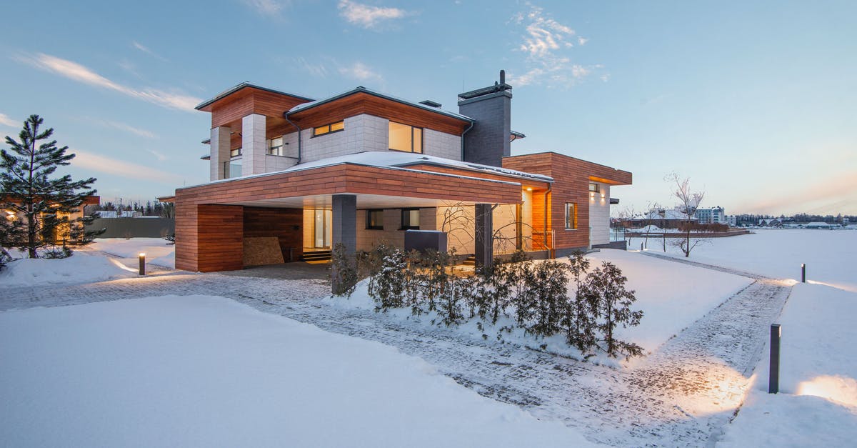 Is it possible to revisit these locations? - Exterior view of luxurious residential house with roofed parking and spacious backyard in snowy winter countryside