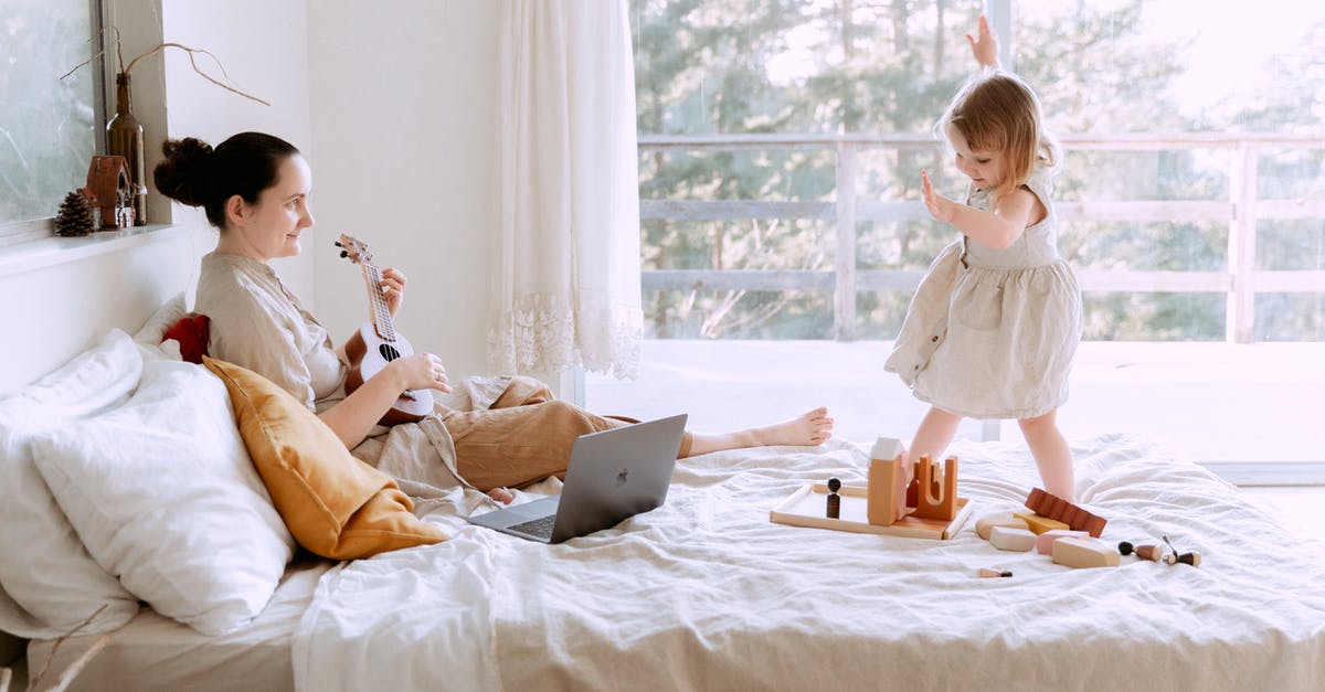 Is it possible to see the content of game updates on Steam? - Happy young woman playing ukulele for daughter at home