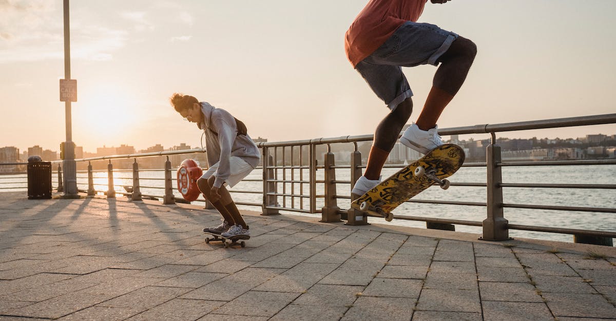 Is it possible to Short Jump on the 3DS? - Young energetic diverse male skaters in casual outfits jumping and performing tricks while riding skateboards on embankment