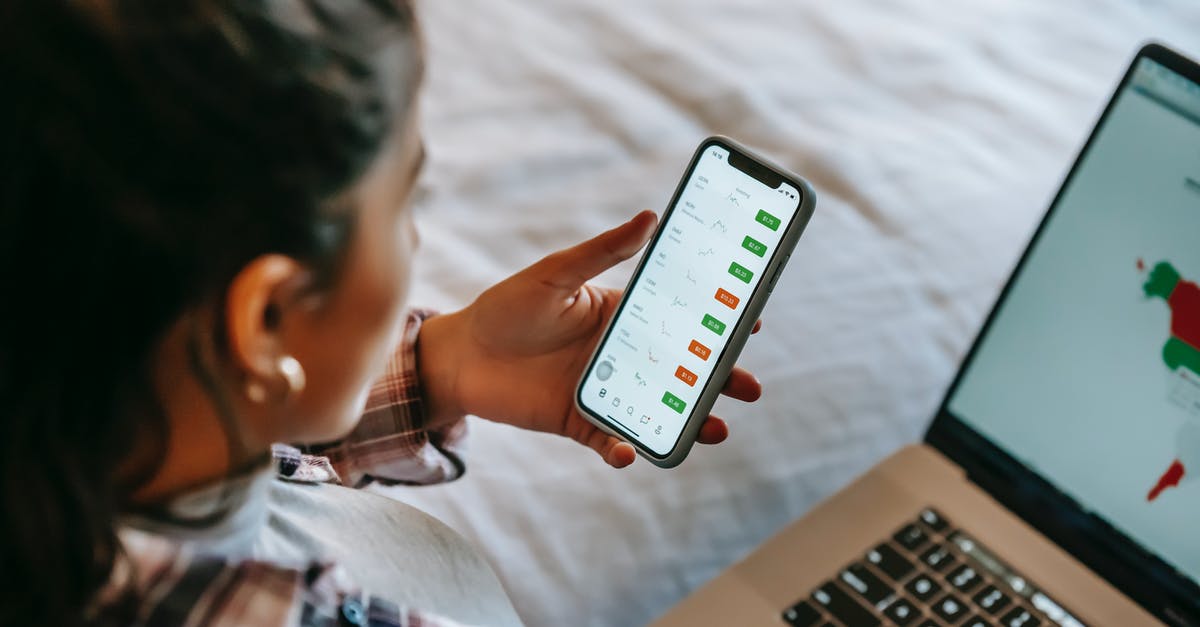 Is it possible to trade from an emulator into a nintendo device? - Crop ethnic analyst using trading application on smartphone on bed