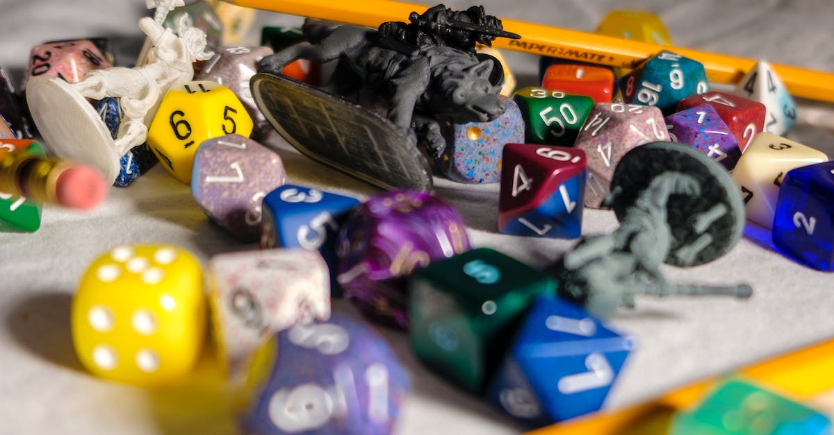 Is it possible to use a PS Vita game voucher on an account for one region and play the games downloaded on an account from a different region? - High angle of color dices in different shapes scattered on table with small toy animals and pencils during game