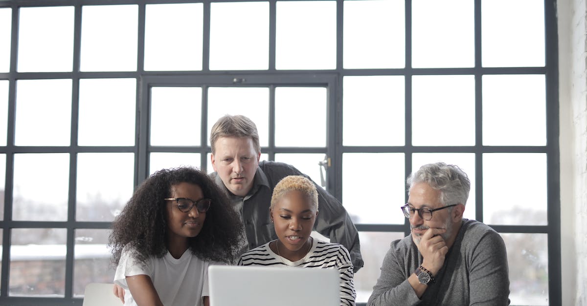 Is it possible to use different teams for different users? - Concentrated multiethnic group working on laptop in office