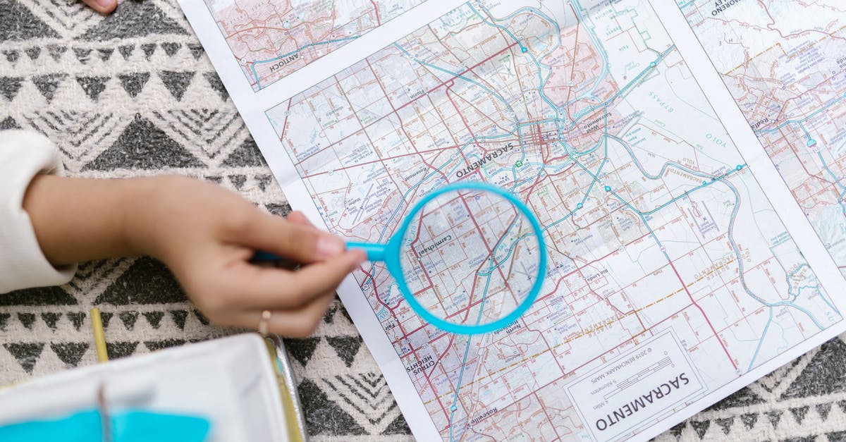 Is it possible to zoom map? - Person Holding Blue Magnifying Glass Over a Map