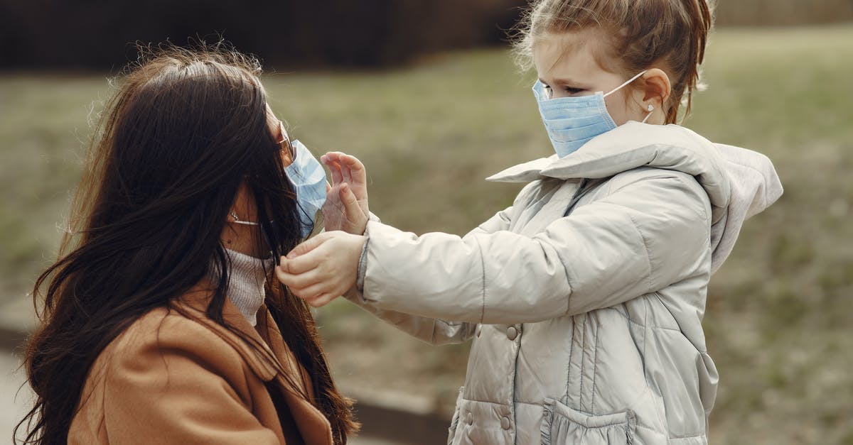 Is it safe to waste time when there is no timed quest or active threat? - Cute little girl in mask helping put on medical mask for mom in sunglasses during stroll in park