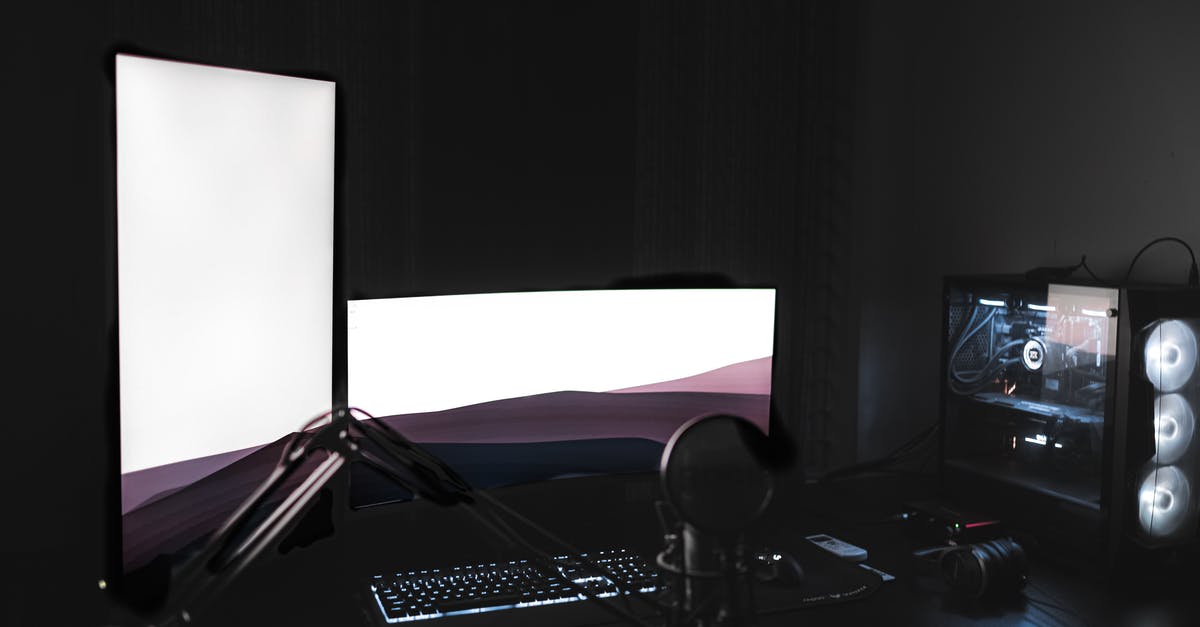 Is it worth keeping Aerondight on New Game+? - Gaming setup with glowing modern monitors placed on black table with keyboard near microphone and system unit in dark room