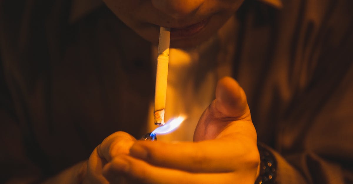 Is Mercy's damage boost applied on fire or on hit? - Crop male with burning lighter and cigarette smoking for reducing stress in light of lamp