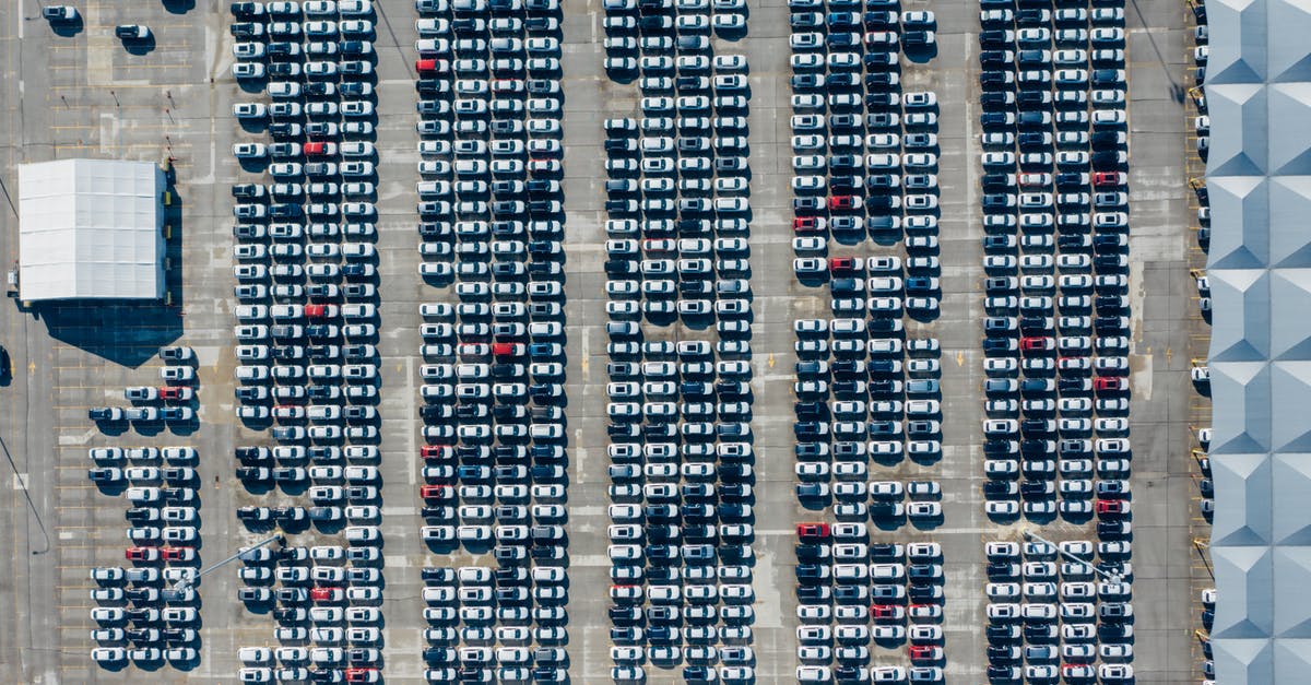 Is placing parks in Industrial area a good idea? - Aerial view of various modern vehicles parked in row on street near modern building on sunny day