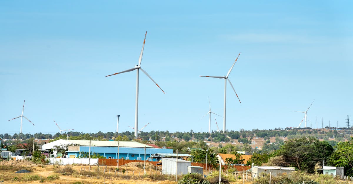 Is Pylon Expand a sustainable build? - Scenic view of wind turbines against houses under cloudy blue sky in countryside in daytime