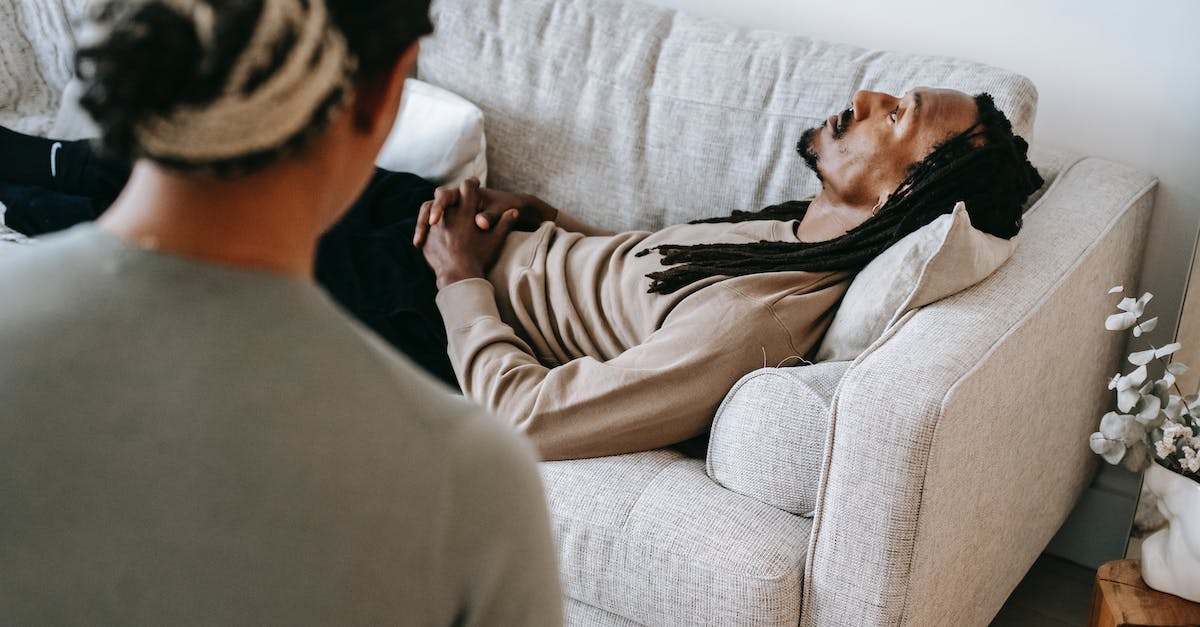 Is Sarah experiencing any psychological disorders? - Black man lying on sofa during psychotherapy