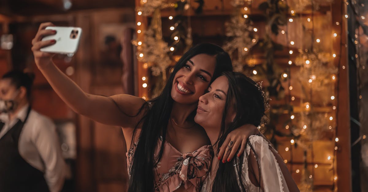 Is the Martian madness event in terraria mobile? - Happy ethnic woman hugging girlfriend and taking selfie on smartphone