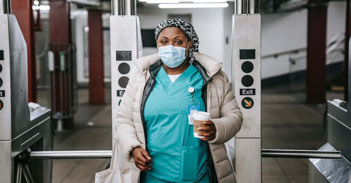Is the season pass shared between PSN accounts? - Calm adult African American nurse with coffee to go wearing warm outfit and protective face mask passing through turnstile in metro station and looking at camera