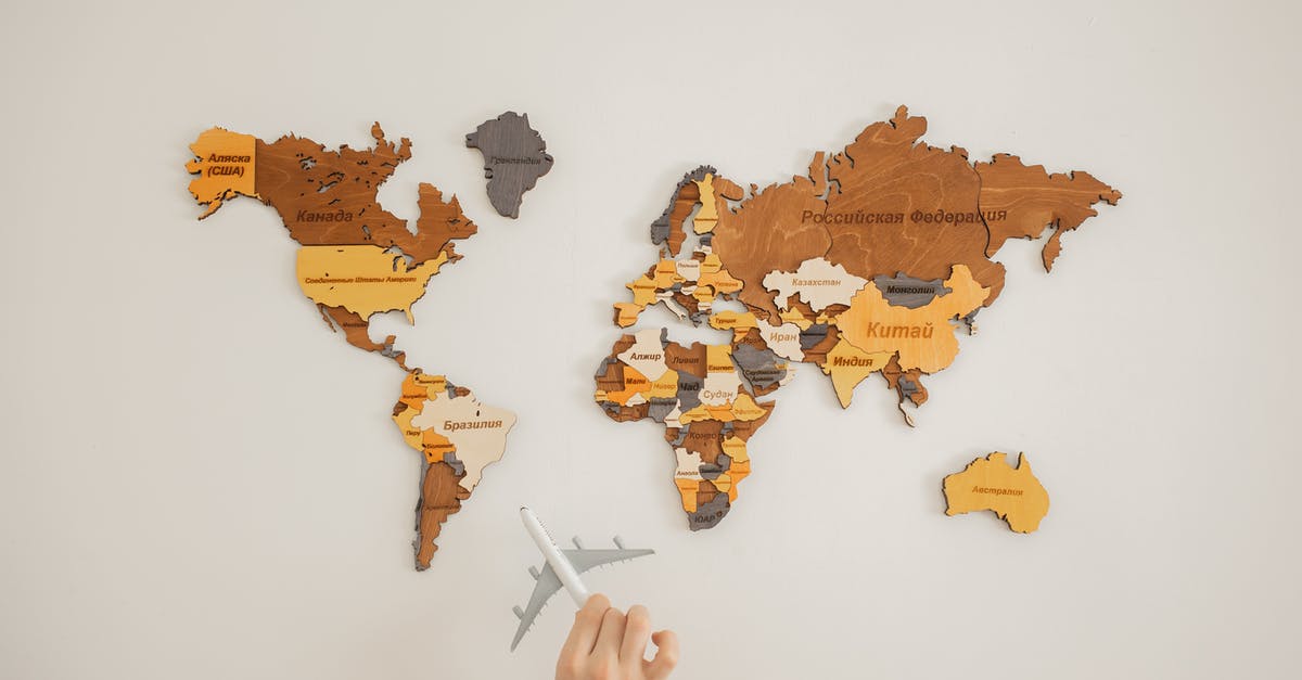 Is there a meaning to the name YoRHa? - Crop unrecognizable person with toy aircraft near multicolored decorative world map with continents attached on white background in light studio