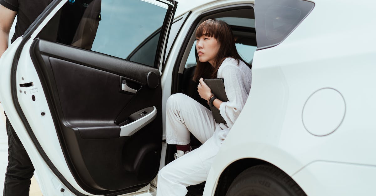 Is there a "knack" to getting vehicle takedowns using hacks? - Thoughtful unemotional Asian female in stylish white clothes with modern tablet getting off white car